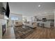 Open-concept living room features hardwood floors, plush couches, and an adjacent kitchen with modern appliances at 18001 Herrera Dr, Parker, CO 80134