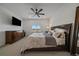 Bright main bedroom with a large bed, ceiling fan, large dresser, and television at 18001 Herrera Dr, Parker, CO 80134