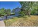 View of the front exterior with a lawn, and mature trees surrounding the property at 6034 S Niagara Ct, Centennial, CO 80111