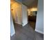 Hallway view with stylish tile flooring leading to a well-lit bathroom with vanity at 10785 W 63Rd Pl # 105, Arvada, CO 80004