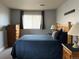 Inviting bedroom with a wooden bed frame, dresser, and ample natural light at 10785 W 63Rd Pl # 105, Arvada, CO 80004