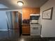 Functional kitchen with stainless steel refrigerator, range and microwave, complemented by granite countertops and wooden cabinets at 10785 W 63Rd Pl # 105, Arvada, CO 80004