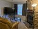 Cozy living room featuring a stone fireplace, large TV, and comfortable seating at 10785 W 63Rd Pl # 105, Arvada, CO 80004