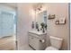 Bathroom with a single vanity, toilet, and decorative shelving at 10723 Sedalia St, Commerce City, CO 80022