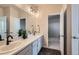 Elegant bathroom with double vanity, framed mirror and modern lighting, plus black hexagonal tile floor at 10723 Sedalia St, Commerce City, CO 80022