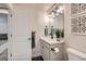 Stylish half bathroom featuring modern vanity, attractive mirror and fixtures, and decorative black and white accent tiles at 10723 Sedalia St, Commerce City, CO 80022