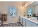 Bathroom with a double vanity, quartz countertops, unique black and white tile, and natural lighting at 10723 Sedalia St, Commerce City, CO 80022