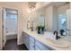 Stylish bathroom featuring double sinks, modern fixtures, and sleek hexagonal tile flooring at 10723 Sedalia St, Commerce City, CO 80022