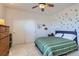 Cozy bedroom with a green and white striped bed, closet, decor on the walls, and a ceiling fan at 10723 Sedalia St, Commerce City, CO 80022