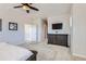 Light and airy bedroom with dark wood furniture, a ceiling fan, and a mounted television at 10723 Sedalia St, Commerce City, CO 80022