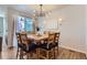 Stylish dining room with a wooden table, seating for eight, contemporary lighting, and natural light at 10723 Sedalia St, Commerce City, CO 80022