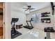 Home gym features an exercise bike, treadmill, shelving, and bright light from a window at 10723 Sedalia St, Commerce City, CO 80022