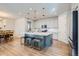 Bright kitchen with a large island, seating, pendant lighting, and views into the dining area at 10723 Sedalia St, Commerce City, CO 80022