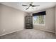 Neutral bedroom features a ceiling fan, shelving unit, and a view to the outdoors at 13087 Krameria St, Thornton, CO 80602