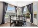 Bright dining room features a round wood table, stylish chandelier, and sliding glass door to patio at 13087 Krameria St, Thornton, CO 80602