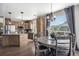 Open kitchen view with a round breakfast nook table, kitchen island and wooden cabinets at 13087 Krameria St, Thornton, CO 80602
