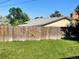Green backyard with a tall wooden fence and a view of the home's roofline at 984 S Braun Dr, Lakewood, CO 80228