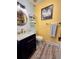 Well-lit half bathroom with modern vanity, painted walls, and updated wood-look floors at 984 S Braun Dr, Lakewood, CO 80228