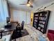 Bright bedroom with a ceiling fan, filled bookshelf, and a view to the en suite bathroom at 984 S Braun Dr, Lakewood, CO 80228