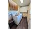 Bright laundry room with modern washer and dryer, wood-look floors, and ample cabinet space at 984 S Braun Dr, Lakewood, CO 80228