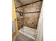 Shower featuring earth-tone stone-look tile, black hardware, and a white shower curtain at 984 S Braun Dr, Lakewood, CO 80228