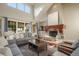 Bright living room with large windows, a stone fireplace, and stylish neutral furniture at 18394 Heavens Pl, Monument, CO 80132