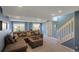 Finished basement with a comfortable seating area and staircase at 9767 Burberry Way, Highlands Ranch, CO 80129