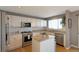 Well-equipped kitchen with granite countertops, stainless steel appliances, white cabinets, and hardwood floors at 9767 Burberry Way, Highlands Ranch, CO 80129