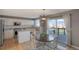 Modern kitchen with white cabinetry, stainless steel appliances, granite countertops, and an adjacent dining area at 9767 Burberry Way, Highlands Ranch, CO 80129