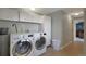 Modern laundry room with front-loading washer and dryer and ample storage at 9767 Burberry Way, Highlands Ranch, CO 80129