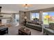Open-concept living room with large windows, lots of natural light, and access to the outdoor patio at 9767 Burberry Way, Highlands Ranch, CO 80129