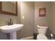 Cozy powder room features modern pedestal sink and toilet; festive decor at 9767 Burberry Way, Highlands Ranch, CO 80129