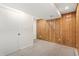 Cozy basement featuring wood paneling, neutral carpet, and white trim at 10663 Dexter Dr, Thornton, CO 80233