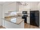 Well-equipped kitchen with white cabinets, granite countertops, modern appliances, and ample natural light at 10663 Dexter Dr, Thornton, CO 80233