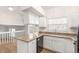 Modern kitchen with granite countertops, white cabinets, and stainless steel appliances, open to the living area at 10663 Dexter Dr, Thornton, CO 80233