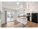 Bright kitchen with white cabinets, granite countertops, stainless steel appliances, and sliding glass door to the deck at 10663 Dexter Dr, Thornton, CO 80233