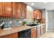 Cherry wood cabinets, backsplash and countertop, with black dishwasher at 5453 S Quatar Ct, Aurora, CO 80015