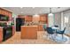 Bright kitchen with island, black appliances, and dining area with walk out patio at 5453 S Quatar Ct, Aurora, CO 80015