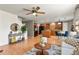 Bright, open-concept living area with wood floors, a ceiling fan, and a view of the kitchen at 5453 S Quatar Ct, Aurora, CO 80015