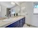 Contemporary bathroom featuring double sinks with navy blue cabinets and mosaic tile backsplash, offering modern style at 5666 S Havana Ct, Englewood, CO 80111