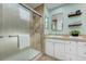 Bathroom featuring a glass shower, a white vanity with marble countertop, and decorative shelves with neatly folded towels at 5666 S Havana Ct, Englewood, CO 80111