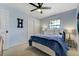 Comfortable bedroom with blue walls, a ceiling fan, a cozy bed with decorative pillows, and a window providing natural light at 5666 S Havana Ct, Englewood, CO 80111