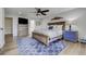 Bright primary bedroom featuring a ceiling fan, light hardwood floors, and a cozy king-size bed with mountain wall art at 5666 S Havana Ct, Englewood, CO 80111