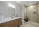 Modern bathroom featuring a glass shower, a wooden vanity, and neutral tile throughout at 4200 W 17Th Ave # 625, Denver, CO 80204