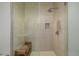 Glass shower with a wooden seat, neutral tile, and a rainfall shower head at 4200 W 17Th Ave # 625, Denver, CO 80204
