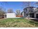 Large green backyard showcasing the modern home's unique architectural details and detached garage at 2025 Ash St, Denver, CO 80207