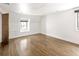 Bright, empty bedroom boasts hardwood floors, recessed lighting, and natural light from two windows at 2025 Ash St, Denver, CO 80207