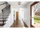 Inviting entryway featuring hardwood floors, chandelier, staircase with iron railing, and door to the outside at 2025 Ash St, Denver, CO 80207