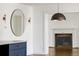 Modern fireplace in a cozy living space, with a round mirror and elegant light fixtures at 2025 Ash St, Denver, CO 80207