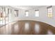 Bright living room with hardwood floors, white trim and walls, and three windows offering natural light at 2025 Ash St, Denver, CO 80207